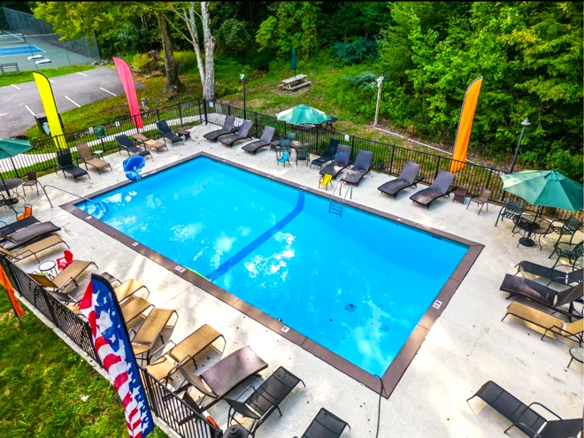 Aerial view of the Shagbark community swimming pool with loungers, umbrellas and the tennis courts beyond