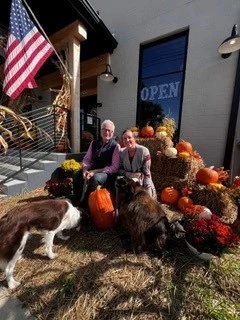 Joe Thielmann and Kathryn Parciak sitting among pumpkins on an autumn afternoon