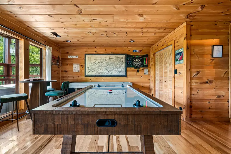 Air hockey table in the game room with doors to the deck